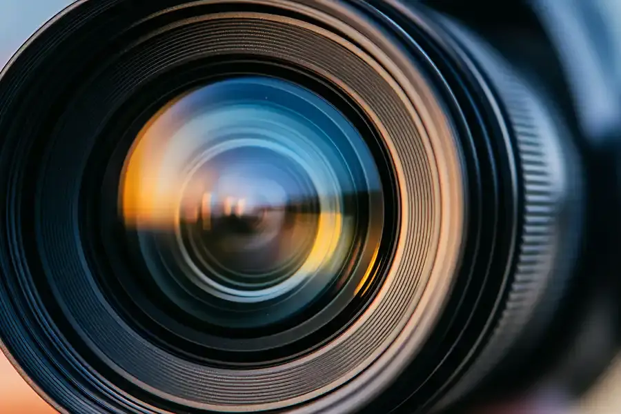 Close-up view of a camera lens with reflections of light and colors on the glass, highlighting the intricate details and circular shapes—perfect for illustrating guides on the Best Image Sizes for Your Website.
